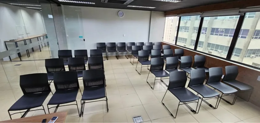 Outra vista do auditório da Seventech, com as fileiras de cadeiras e as janelas do 14º andar